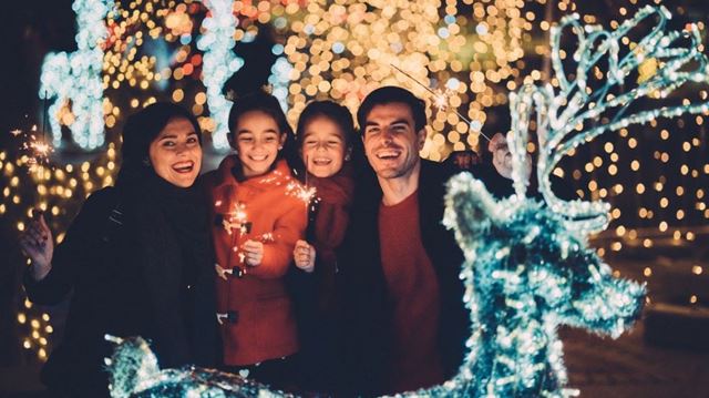 Family of four enjoying Christmas lights